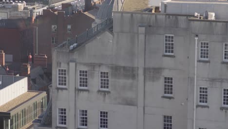 tilt down from birds eye view, manchester city centre building, birds fly through from 5 seconds, slow-motion 4k