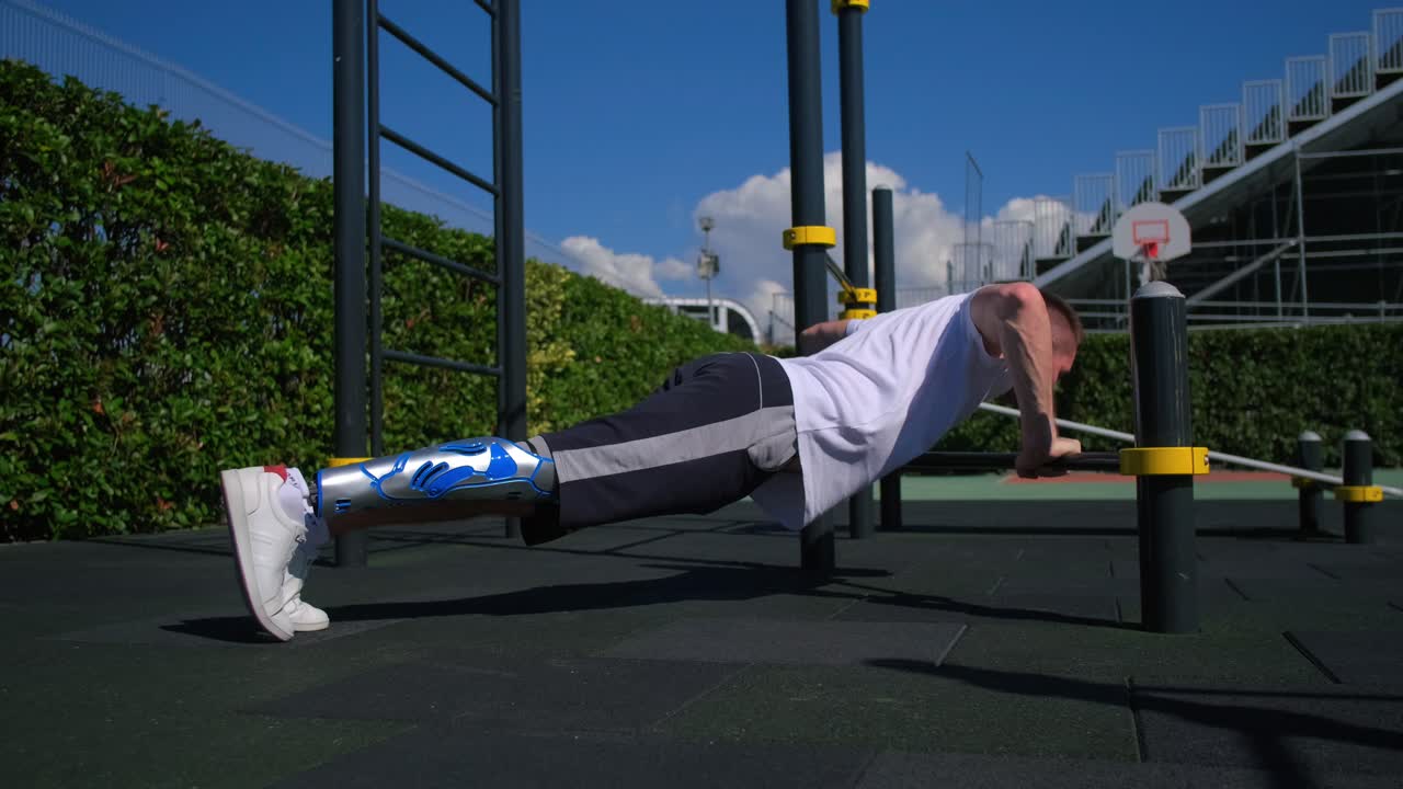 hombre con soporte para las piernas haciendo flexiones en el gimnasio al aire libre