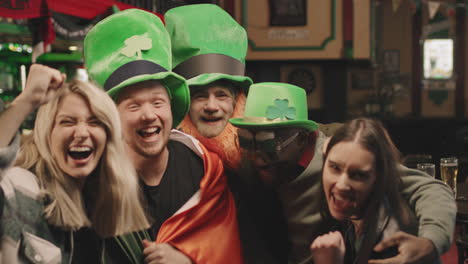 cheerful friends celebrating st patricks day at pub