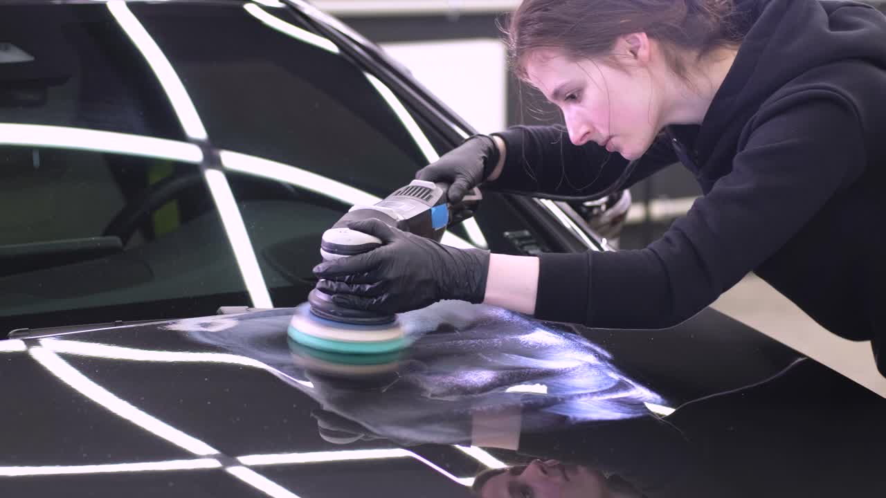 페인트 복원을 위해 기계와 폴리셔를 사용하는 전문 자동차 디테일링.