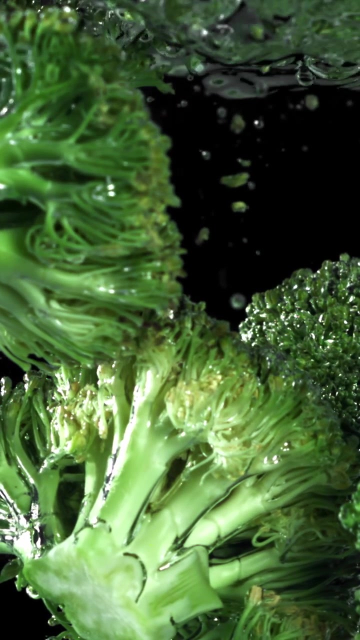 Broccoli verdi freschi che si immergono nell'acqua al rallentatore