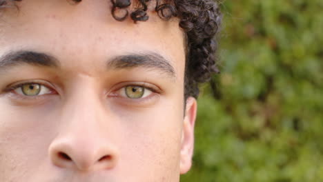 biracial man face close up and looking into camera outdoors, slow motion