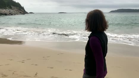 4K-Senior-walking-down-Sand-Beach-at-Acadia-National-Park-in-Maine