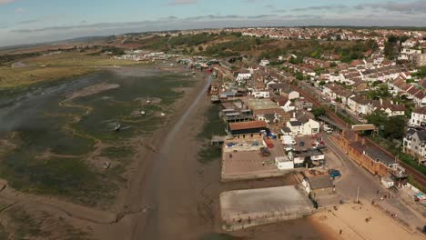 Smooth-flight-over-wharf-business-and-train-tracks-coastal-fishing-village-over-marshes