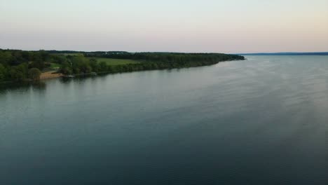 Hermoso-Vuelo-Aéreo-De-Drones-Sobre-Los-árboles-Verdes-En-Las-Orillas-Del-Lago-Seneca-Nueva-York-Al-Atardecer