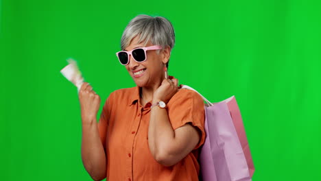mujer feliz, dinero en efectivo y bolsas de compras en verde