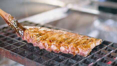 chef preparing pork ribs on grill