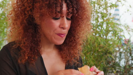 at the gourmet restaurant a woman eating and enjoying the fish burger