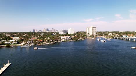 great-aerial-drone-shot-of-beach-and-sand-with-calm-waters-buildings-on-the-side-blue-water-blue-sky-palm-trees-ft