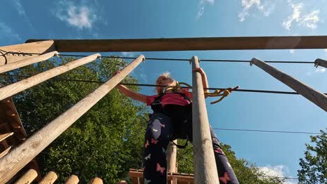 Glückliches-Kleines-Mädchen,-Das-In-Der-Tarzan-Attraktion-Auf-Dem-Spielplatz-Im-Vergnügungspark-Spielt