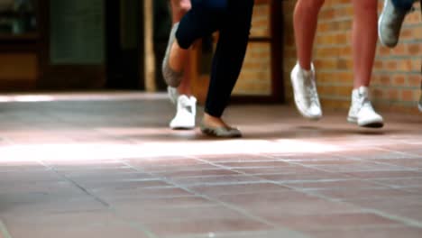 compañeros de clase emocionados corriendo con tarjetas de calificación en el pasillo