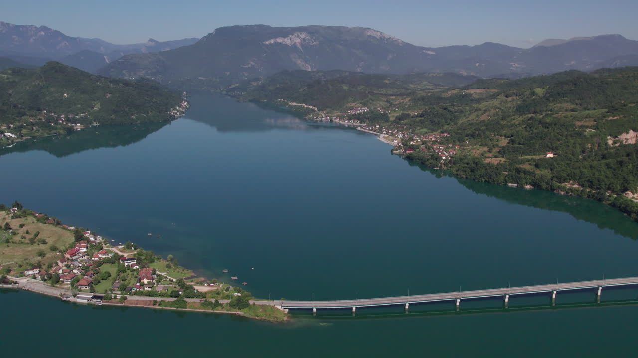 Auto che passano su un ponte sopra un lago bellissimo.