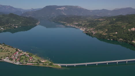 cars passing beautiful lake on a bridge