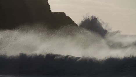 blue waves roll into the coast of hawaii and crash into the shore in slow motion during a big storm 1