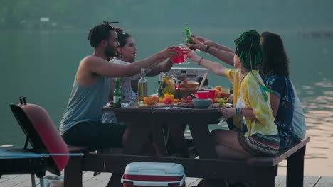 young people toasting and drinking at lake party