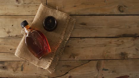 video of maple syrup in bottle and fabric on wooden surface