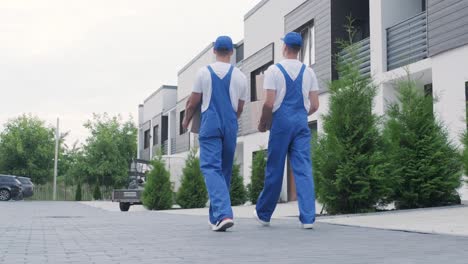 two young workers of removal company deliver boxes to a customer's home