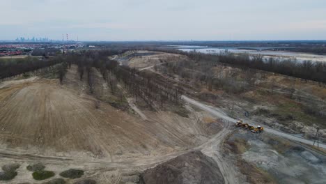 aerial view of sand mining region beside river and industrial factory in background