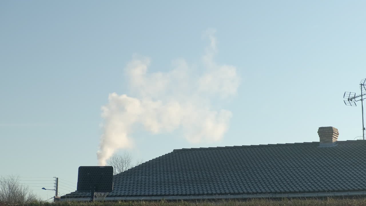 A house chimney smoking by cold weather in winter