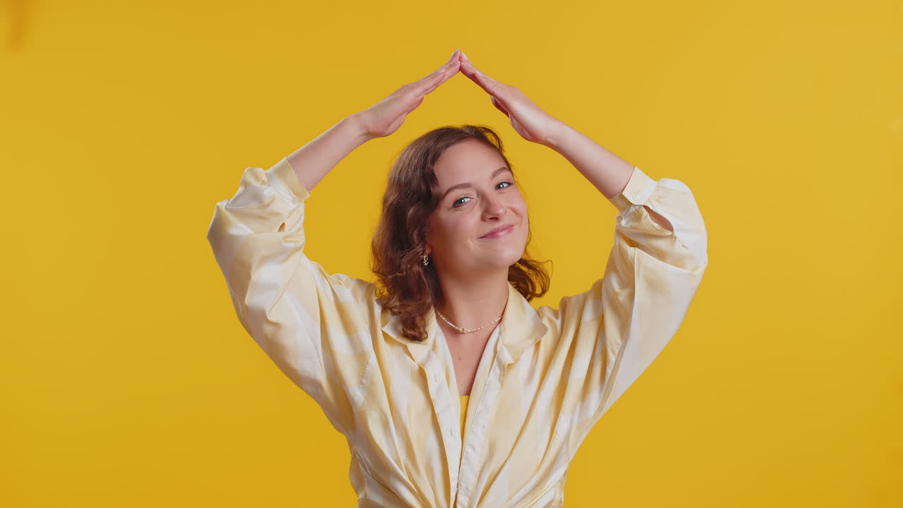 Woman feeling in safe making roof above head with hands insurance security service playing game