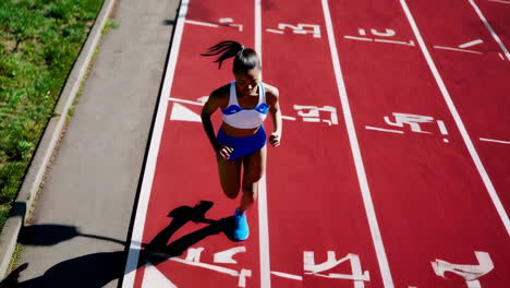 a woman runs on an athletic track