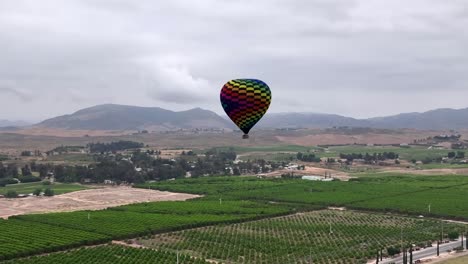 aerial of hot air balloon over temecula vineyard wine country on a cloudy morning adventure