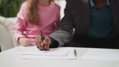 african-american man draws picture teaching girl english