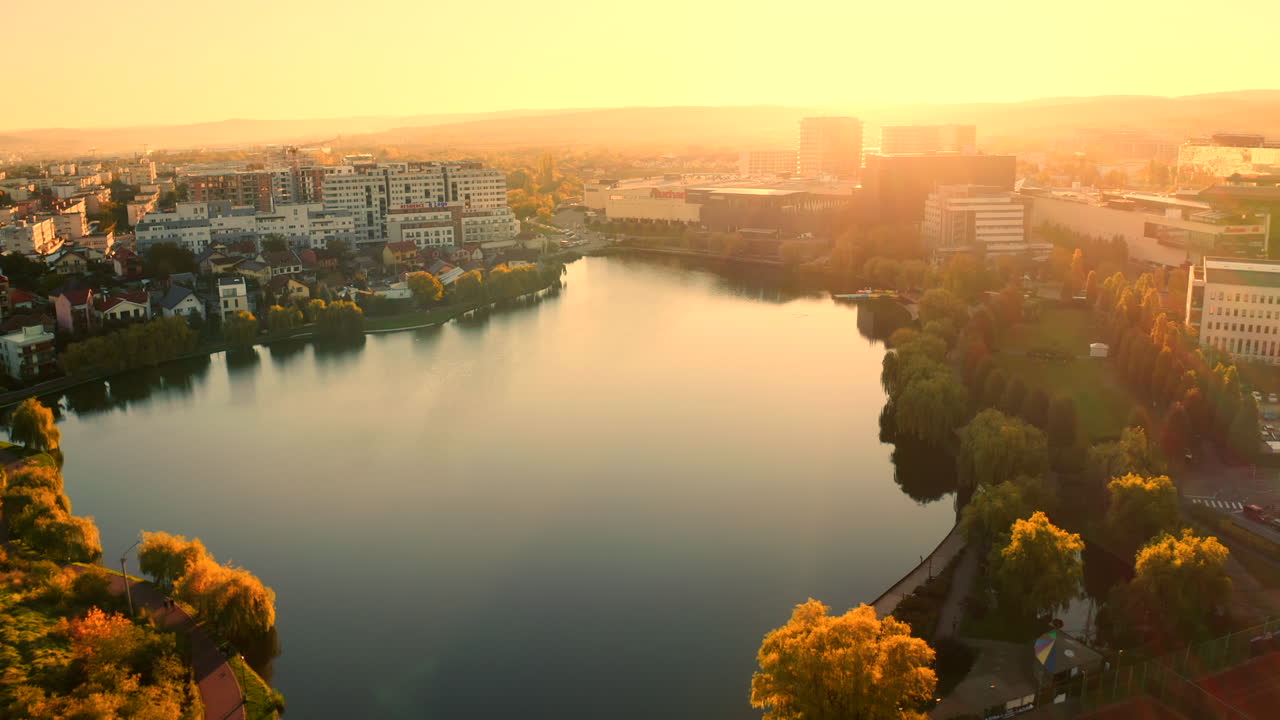 amanecer, cinemático, estableciendo un disparo aéreo de drones sobre la ciudad de cluj-napoca, zona comercial iulius, parque iulius, vista al lago