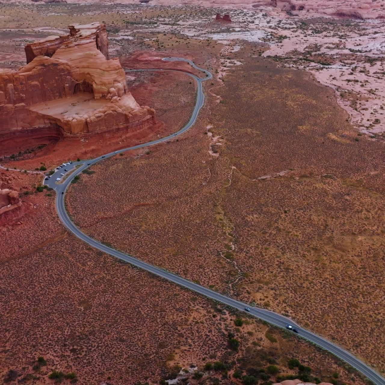 Red rock formations in the middle of deserted landscape. Road with cars through the National park of Zion, Utah, USA. Top view