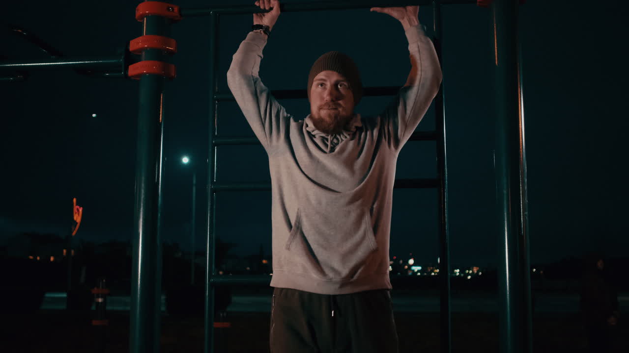 공원에서 밤에 풀업을 하는 남자