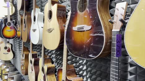 shop for acoustic guitars of various sizes and colors. concept of musical instruments. vertical video