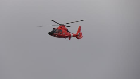 coast guard helicopter flies over beach