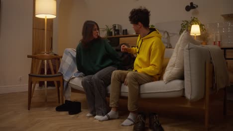 couple relaxing and taking off shoes on a couch