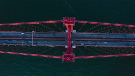 Vista-Aérea-Aérea-Del-Intenso-Tráfico-De-Automóviles-A-Través-Del-Puente-Rojo-Ponte-25-De-Abril-En-Lisboa,-Portugal