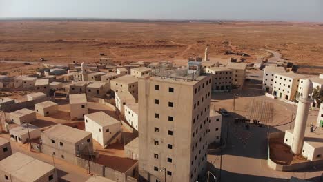 aerial shot of a big bulding in an old empty city in the desert in palestine near gaza cmaera orbit around it