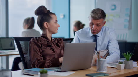 Smiling-female-and-male-employee-talking-in-open-space