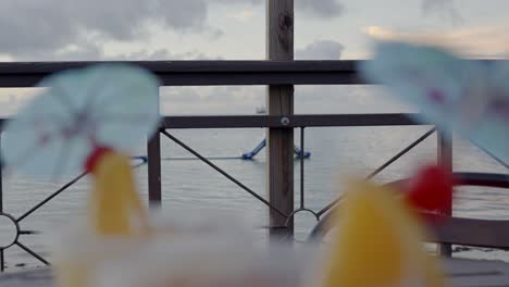 close up shot of orange and cherry on an umbrella stick of cocktail drinks
