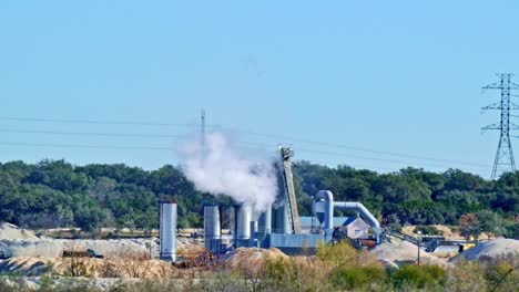 Steam-or-smoke-being-released-into-the-atmosphere-from-a-industrial-plant