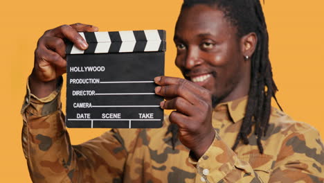 african american film producer using clapperboard