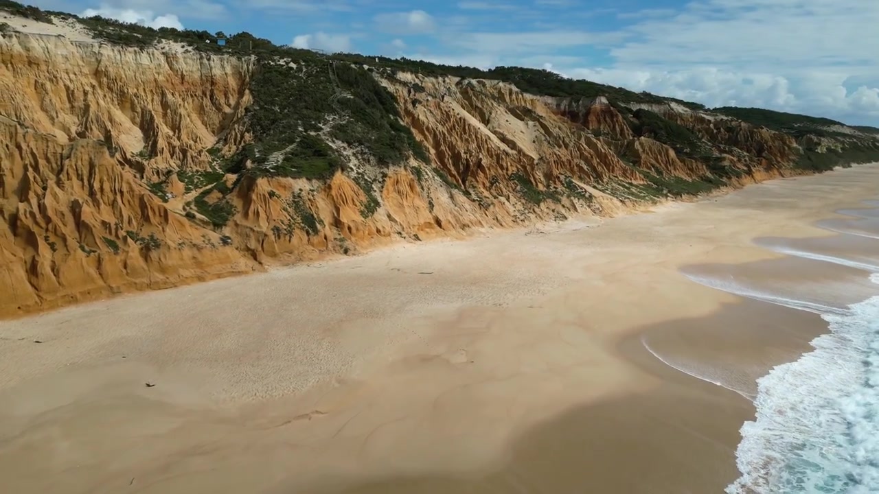 Riprese aeree con drone di Praia do Pinheirinho, Portogallo: costa atlantica selvaggia, spiaggia sabbiosa e scogliere aspre sotto luce naturale. Ideale per progetti di viaggio, estivi e paesaggistici