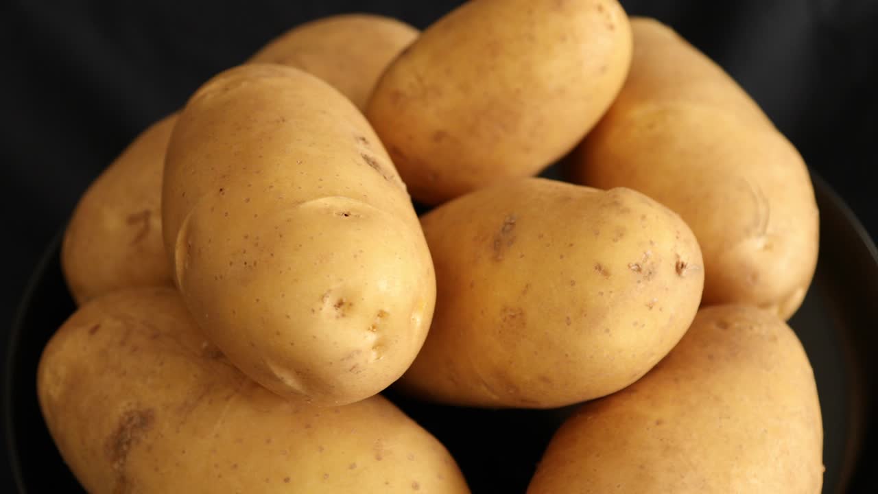 patatas crudas que giran y giran aisladas sobre un fondo negro 5