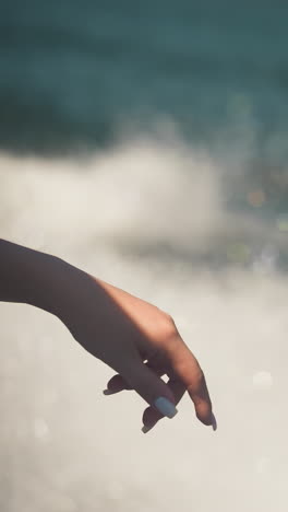 elegant woman hand against foam trail at yacht cruise closeup. lady enjoys freshness on motorboat sailing sea on summer vacation. marine scene