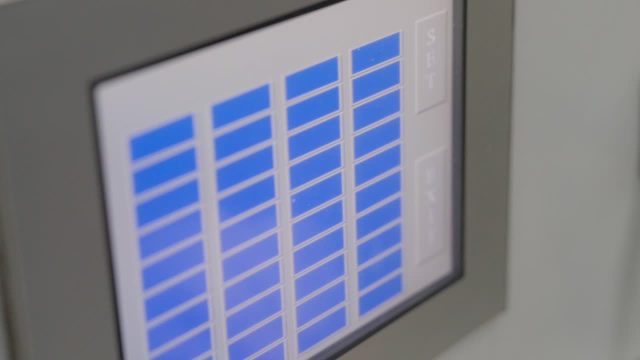 Worker Operating A CNC Machine Controlling Parameters On Touchscreen Display.