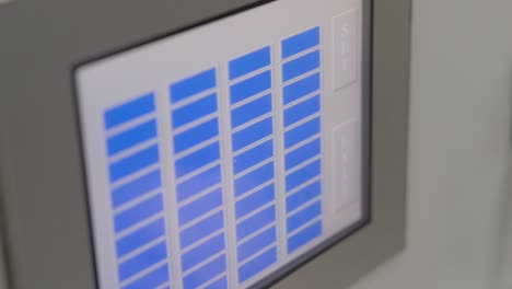worker operating a cnc machine controlling parameters on touchscreen display.