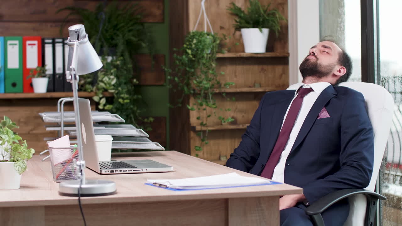 Uomo d'affari stanco che dorme alla sua scrivania in ufficio