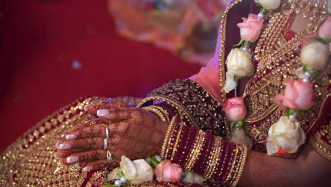 applying turmeric haldi on hands of bride during an extravagant religious wedding ceremony in india, asia. close up shot of ritual with bride and groom hands