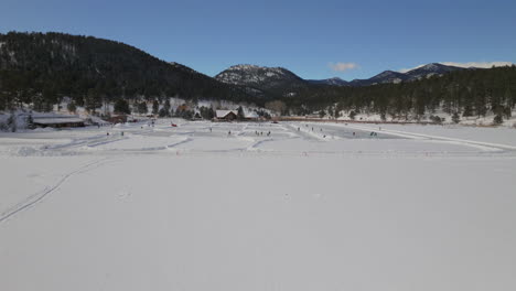 Patinaje-Sobre-Hielo-Patinar-Pista-De-Hockey-Lago-Estanque-Hockey-Invierno-Etown-Casa-Del-Lago-De-Hoja-Perenne-Denver-Campo-De-Golf-Colorado-Antena-Cinematográfico-Zumbido-Soleado-Cielo-Azul-Mañana-Invierno-Fresco-Nieve-Adelante-Movimiento-Ascendente