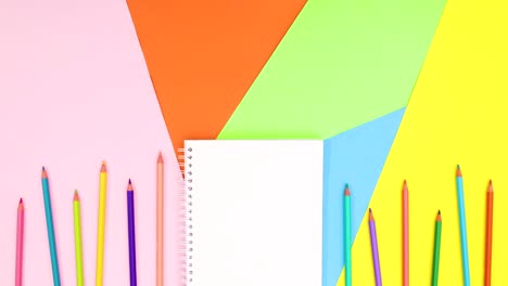 los lápices de colores se mueven en la parte inferior con el cuaderno.