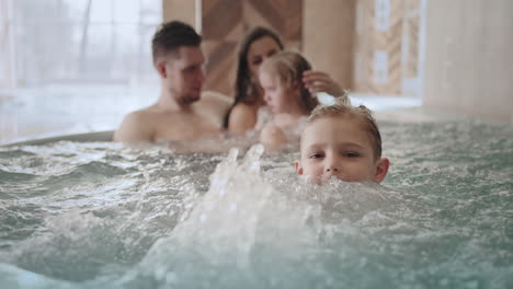 La-Familia-Feliz-Descansa-En-El-Moderno-Centro-De-Spa-El-Fin-De-Semana,-Los-Padres-Con-Su-Hija-Y-Su-Hijo-Se-Relajan