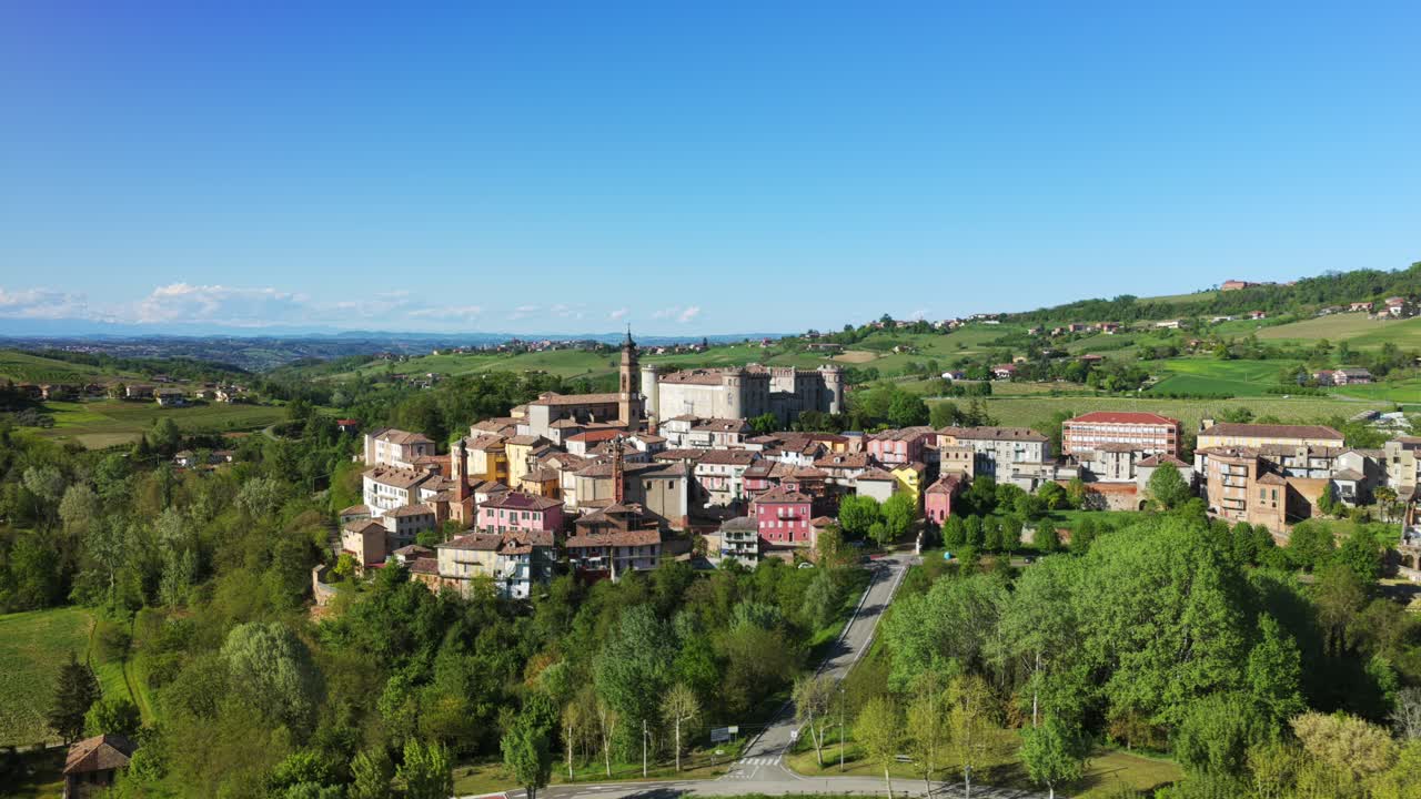 Costigliole d'Asti hilltop village and castle, Italy. Aerial drone orbiting, lateral view, copy space